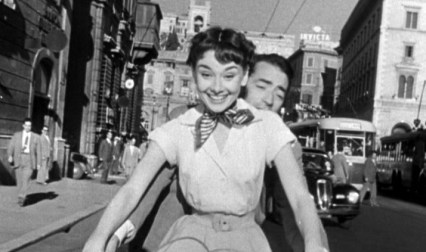 Audrey_Hepburn_and_Gregory_Peck_on_Vespa_in_Roman_Holiday_trailer